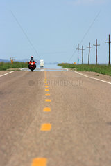 Seligman  USA  auf einem Highway in Arizona kommt ein Motorradfahrer entgegen