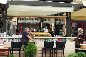 Posen  Polen  Mann sitzt an einer Theke in einem Strassencafe