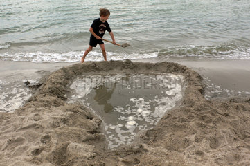 Insel Poel  Deutschland  Junge spielt am Strand im Sand