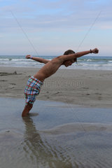 Cocoa Beach  USA  Junge steckt am Strand im Sand fest