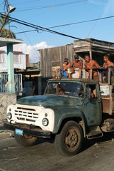 Santiago de Cuba  Kuba  Maenner fahren auf einem alten Truck durch die Strassen