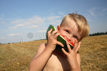 Prangendorf  Deutschland  Junge isst ein Stueck Wassermelone