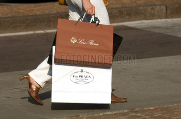 Mailand  Italien  eine Frau traegt Einkaufstueten der Marken Loro Piana und Prada