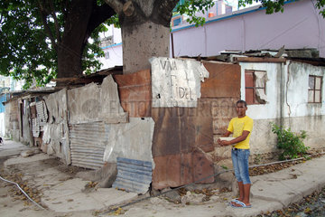 Havanna  Kuba  ein junger Mann steht an einer Strassenecke vor der Parole Viva Fidel