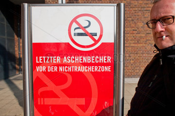Berlin  Deutschland  rauchender Mann neben dem Hinweis: letzter Aschenbecher vor der Nichraucherzone