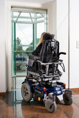 Riedlingen  Deutschland  Frau im Rollstuhl faehrt in einen Fahrstuhl hinein