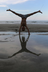Cocoa Beach  USA  Junge macht am Strand einen Handstand