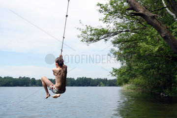 Briescht  Deutschland  Junge schwingt sich an einer Badestelle mit einem Seil durch die Luft