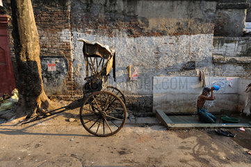 Kolkata  Indien  Asien  Ein Rikschalaeufer duscht am Strassenrand