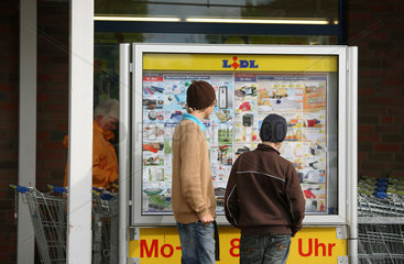 Tostedt  Deutschland  Passanten lesen die Lidl-Angebotstafel