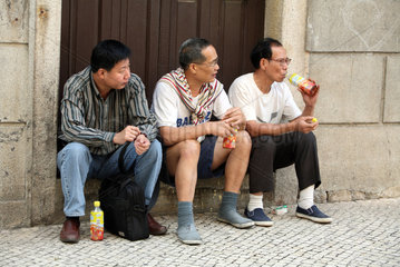 Macau  China  Maenner sitzen auf einer Treppenstufe