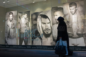 Berlin  Deutschland  Passantin vor einem Schaufenster mit David Backham-Plakaten