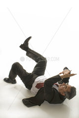 Mann liegt am Boden - hebt schuetzend die Arme