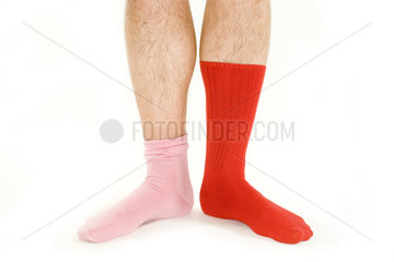 Mann traegt unterschiedliche Socken in rosa und rot