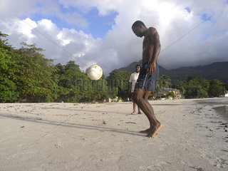 Seychellen  Beau Vallon Beach  zwei Maenner spielen am Strand