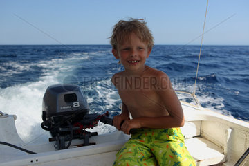 Alicudi  Italien  Junge lenkt ein Motorboot auf dem Meer