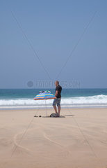 Mann mit Sonnenschirm am Strand