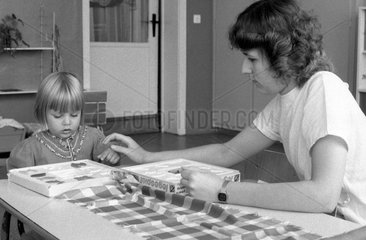 Berlin  DDR  Erzieher spielt mit einem kleinen Maedchen ein Legespiel
