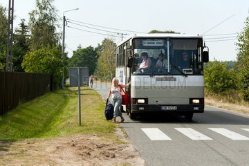 Miodary  Polen  Fahrgaeste steigen aus einem Ueberlandbus aus