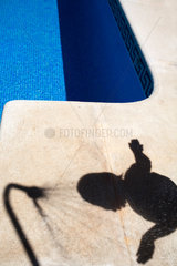 Ayamonte  Spanien  Schatten eines kleinen Maedchens am Swimmingpool
