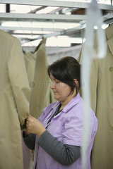 Istanbul  Tuerkei  Mitarbeiterin bearbeitet Maentel in einer Textilfabrik