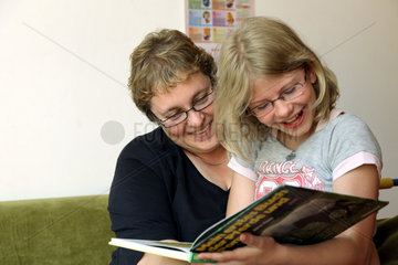 Berlin  Deutschland  Kinderdorf-Mutter liest mit einem Kind ein Buch