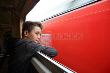 Hannover  Deutschland  Junge schaut aus einem Zugfenster heraus