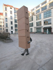 Mann traegt viele Kartons