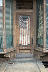 New York City  USA  verfallenes Haus mit amerikanischer Flagge in der Tuer