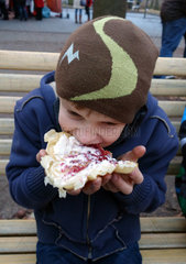 Berlin  Deutschland  Junge isst eine Waffel mit Kirschen und Schlagsahne