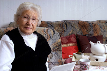 Nauen  Deutschland  eine Rentnerin liest bei einer Tasse Tee