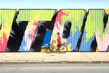 New York City  USA  Frau mit Fahrrad vor einem Graffiti