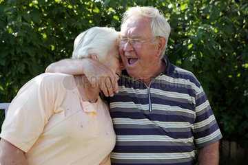 Berlin  Deutschland  Mann umarmt lachend seine Frau