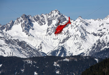 Jerzens  Oesterreich  Rettungshubschrauber der Bergwacht im Flug vor dem Alpenpanorama