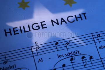 Berlin  Deutschland  ein Weihnachtsstern faellt auf die Notenblaetter eines Weihnachtsliedes
