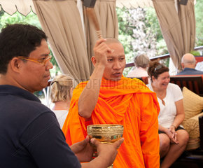 Phnom Penh  Kambodscha  buddhistischer Moench segnet die Crew des Flussschiffes Jayavarman