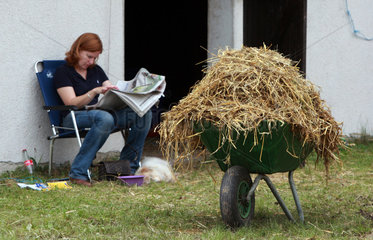 Iffezheim  Deutschland  Pferdepflegerin macht Pause nach dem Ausmisten des Stalles