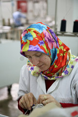 Istanbul  Tuerkei  Mitarbeiterin an einer Naehmaschine in einer Textilfabrik