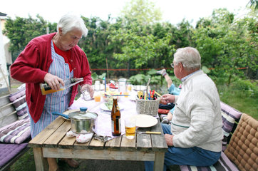 Berlin  Deutschland  Rentnerpaar isst im Garten zu Mittag