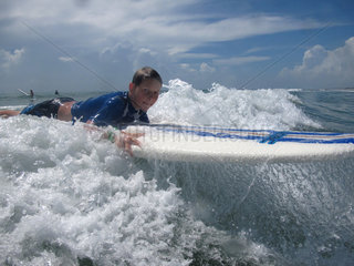 Cape Canaveral  USA  Junge liegt im Meer auf seinem Surfbrett