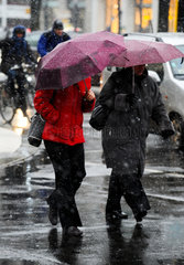 Berlin  Deutschland  Passanten mit Regenschirm bei Schneeregen