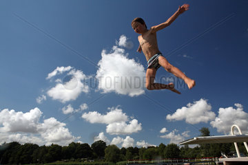 Neukloster  Deutschland  Junge springt von einem Sprungbrett ins Wasser