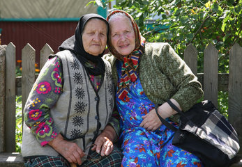 Domsarycy  Weissrussland  zwei alte Frauen sitzen vor ihrem Haus auf einer Bank