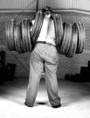 man carrying 8 tyres