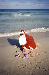 Weihnachtsmann spielt am Strand