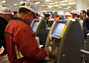Hong Kong  China  Menschen wetten an elektronischen Wett-Terminals