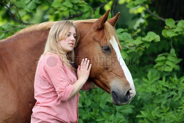 Muehlenbeck  Deutschland  Maedchen schmust mit ihrem Pferd