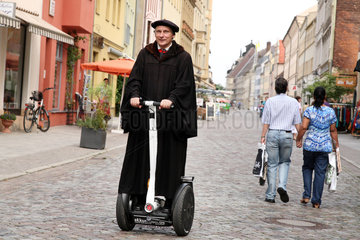 Wittenberg  Deutschland  Lutherdarsteller Bernhard Naumann mit einem Segway-Roller