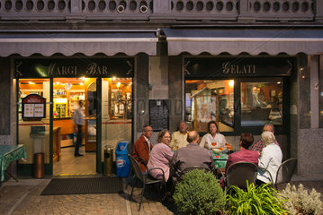 Tirano  Italien  Gaeste einer Bar in der Abenddaemmerung