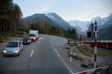 Bernina Suot  Schweiz  Blick auf Autos an einem Bahnuebergang